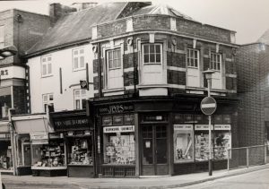 Black and white photo of a chemist shop on a street corner
