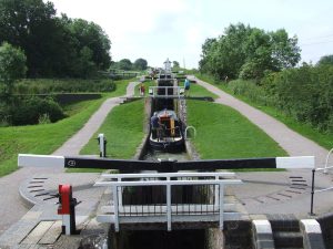 A view up a hill with a canal lock in the foreground, and several more rising up the hill