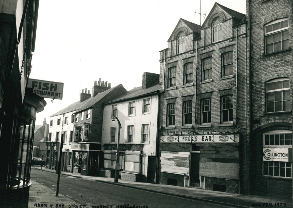 An old photograph of a row of shops, restaurants and bars