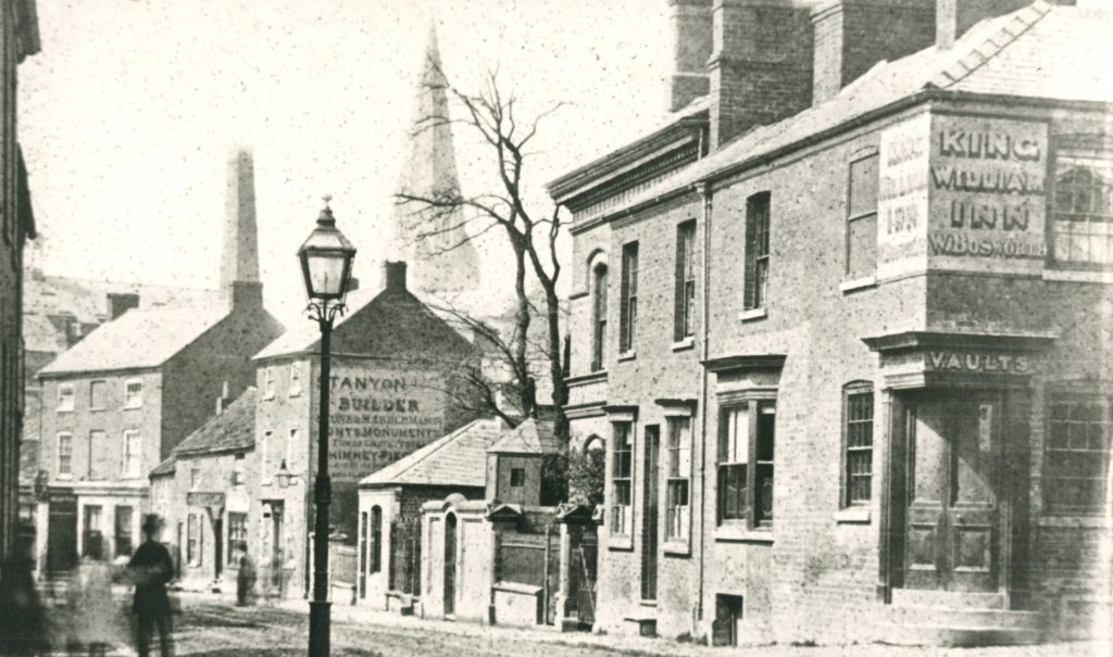An old photograph of a row of houses with painted advertisements on some of them