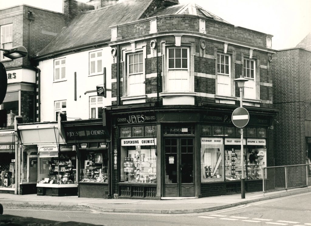 An old photo of a chemists shop on a street corner